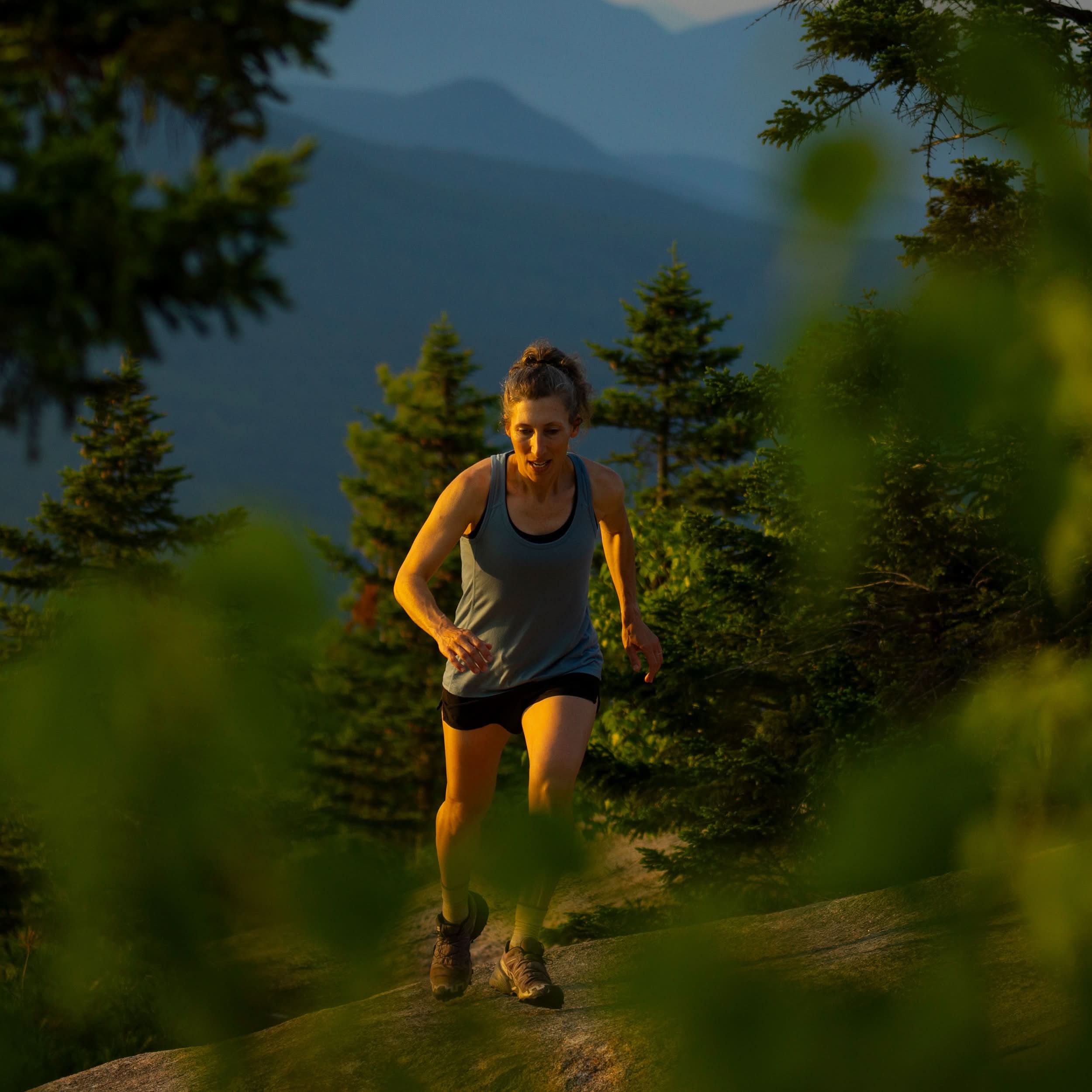Womens microweight tank top super light merino wool for summer, woman hiking on a mountain trail