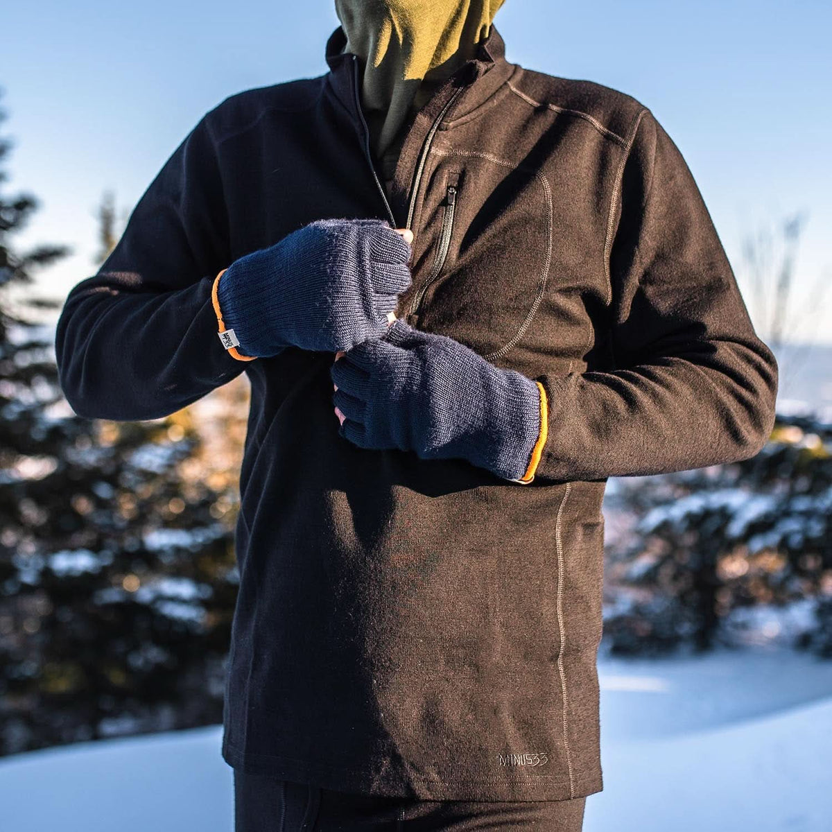 Expedition - Men's Wool 1/4 Zip Wilderness - Minus33 Merino Wool Clothing, close-up of gloved hands unzipping a black quarter-zip top