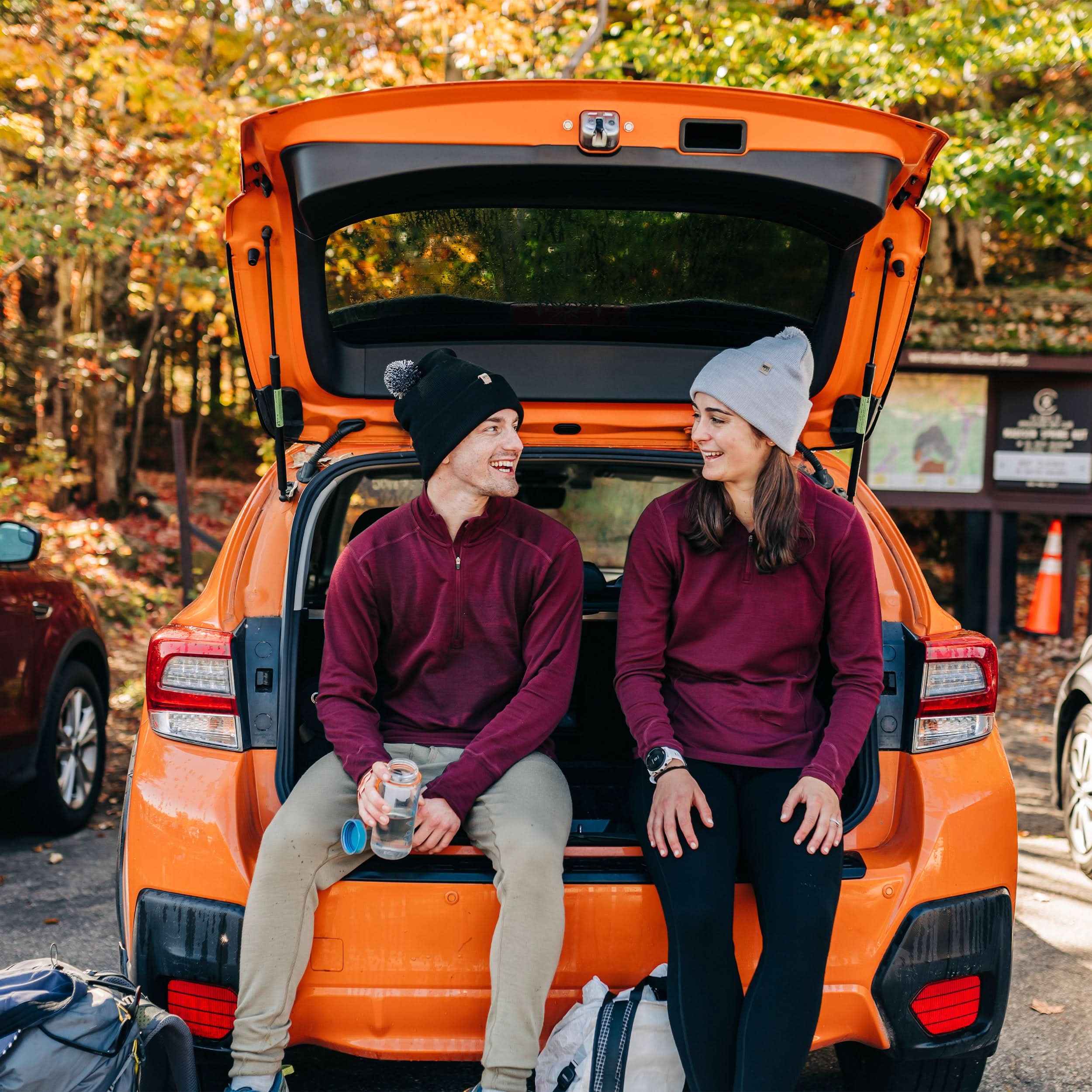 A man models the merino wool midweight quarter zip sweater, complete with flat-lock seams and thumbholes, front three-quarter view outdoors