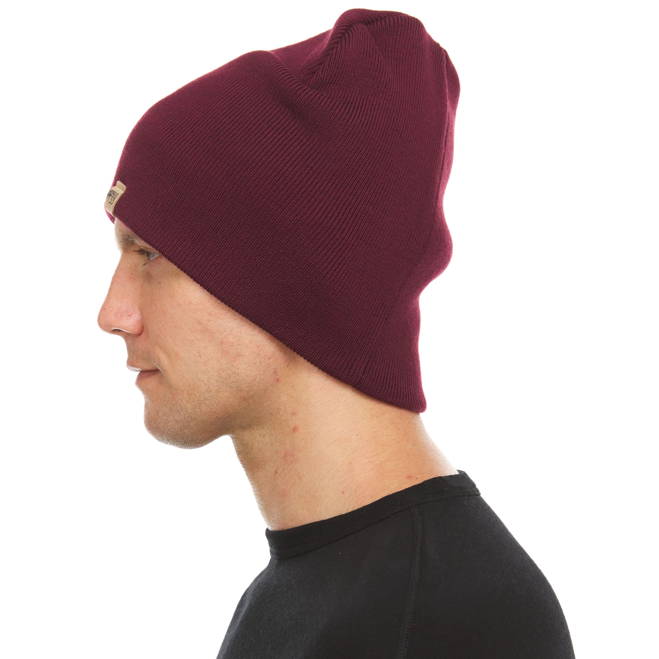 A man models a heavyweight, super soft, one hundred percent merino wool beanie. This heavyweight beanie is the warmest hat that we offer, perfect for hiking through the White Mountains, or sitting at a bonfire in January., right-facing side view