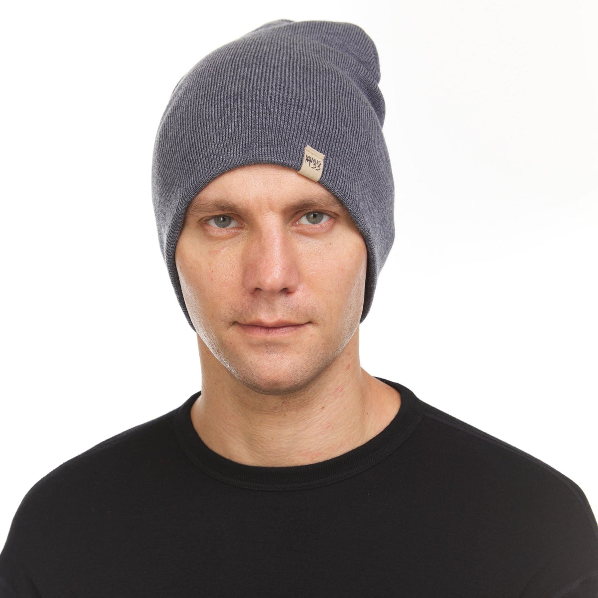 A man models a heavyweight, super soft, one hundred percent merino wool beanie. This heavyweight beanie is the warmest hat that we offer, perfect for hiking through the White Mountains, or sitting at a bonfire in January, front view