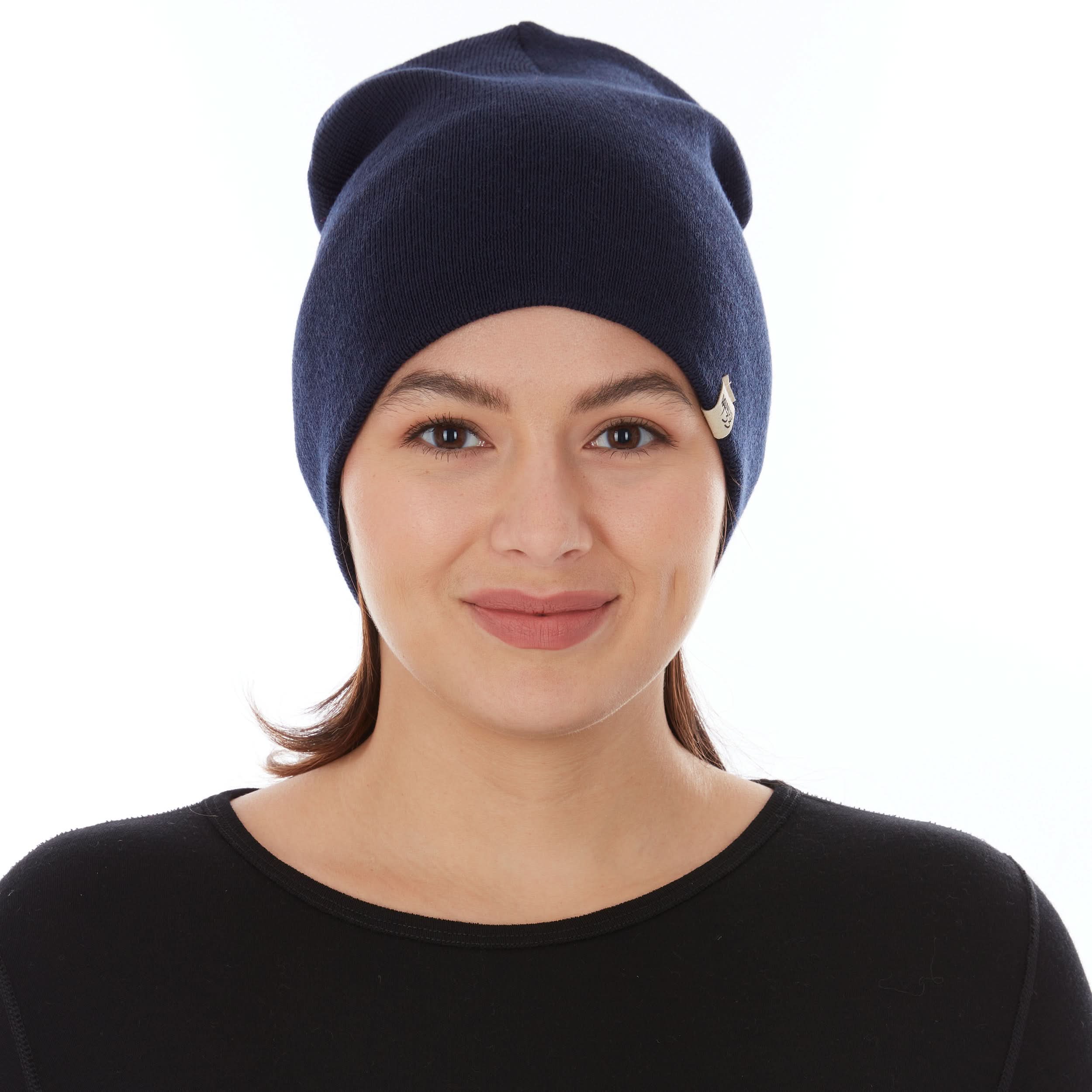 A woman models a heavyweight, super soft, one hundred percent merino wool beanie. This heavyweight beanie is the warmest hat that we offer, perfect for hiking through the White Mountains, or sitting at a bonfire in January.