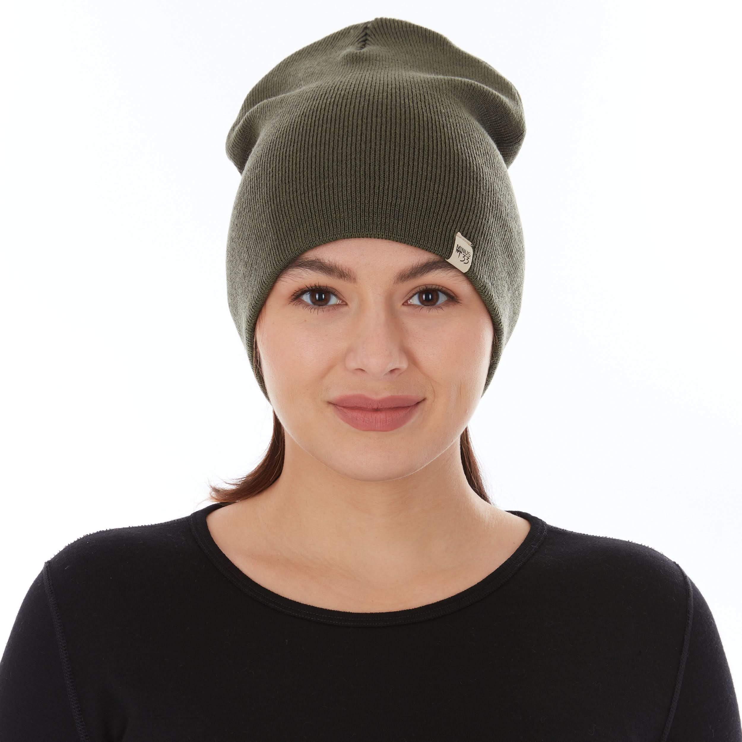 A woman models a heavyweight, super soft, one hundred percent merino wool beanie. This heavyweight beanie is the warmest hat that we offer, perfect for hiking through the White Mountains, or sitting at a bonfire in January.