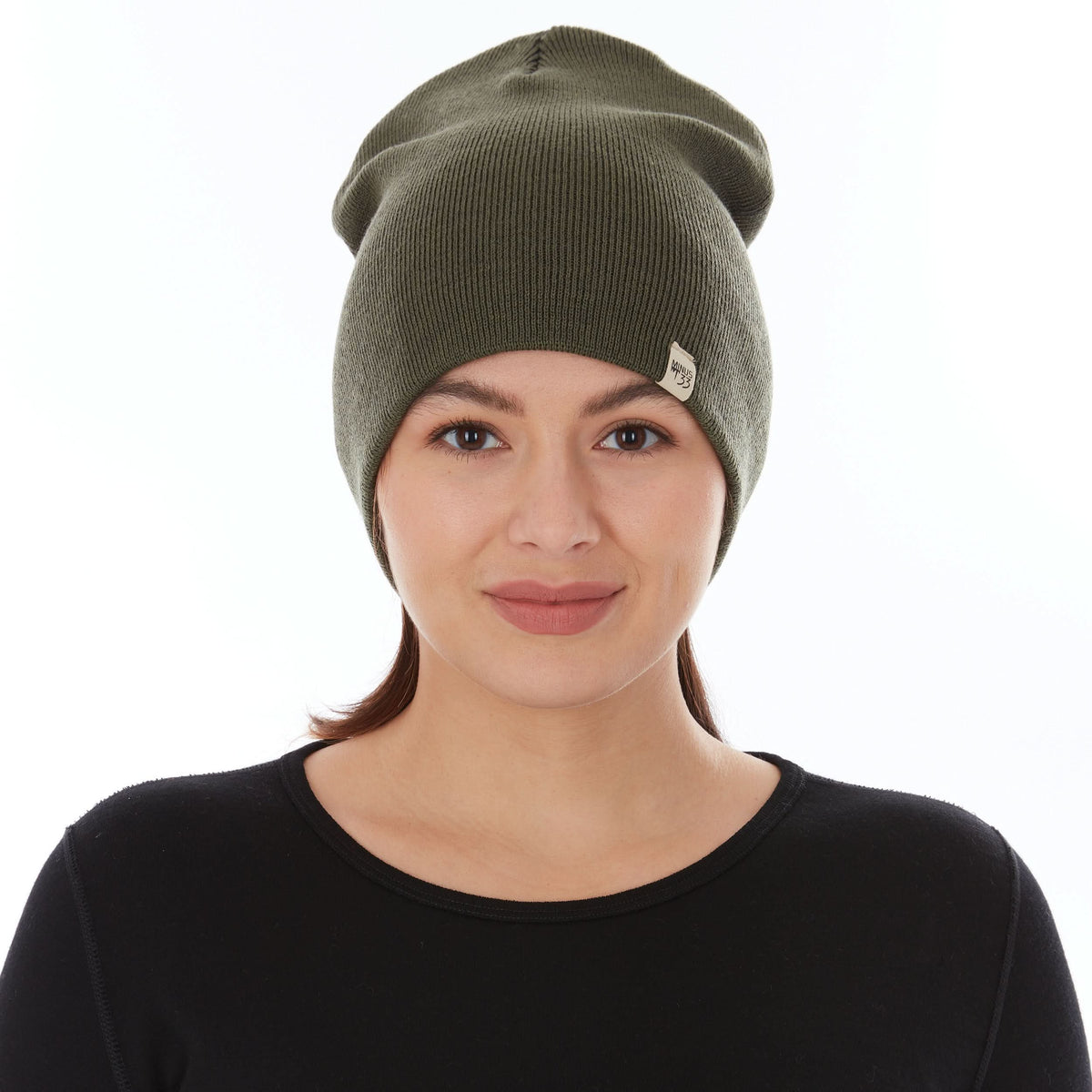 A woman models a heavyweight, super soft, one hundred percent merino wool beanie. This heavyweight beanie is the warmest hat that we offer, perfect for hiking through the White Mountains, or sitting at a bonfire in January.