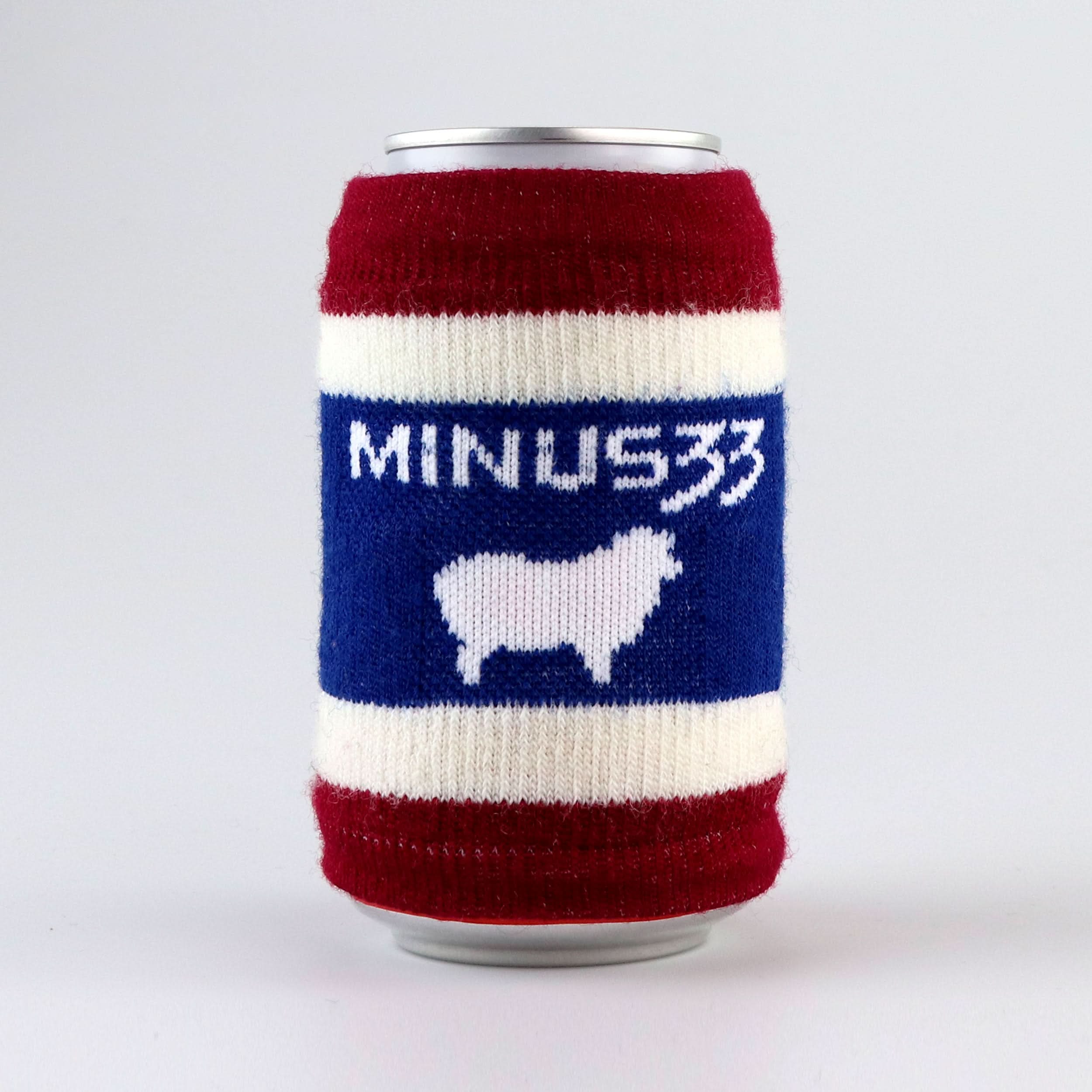 Red, white, and blue knit can cooler featuring a Minus33 wordmark and white sheep graphic.