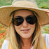 Sunski Astra Polarized Sunglasses - Tortoise Amber - Woman wearing a straw hat and sunglasses with a blurred natural background
